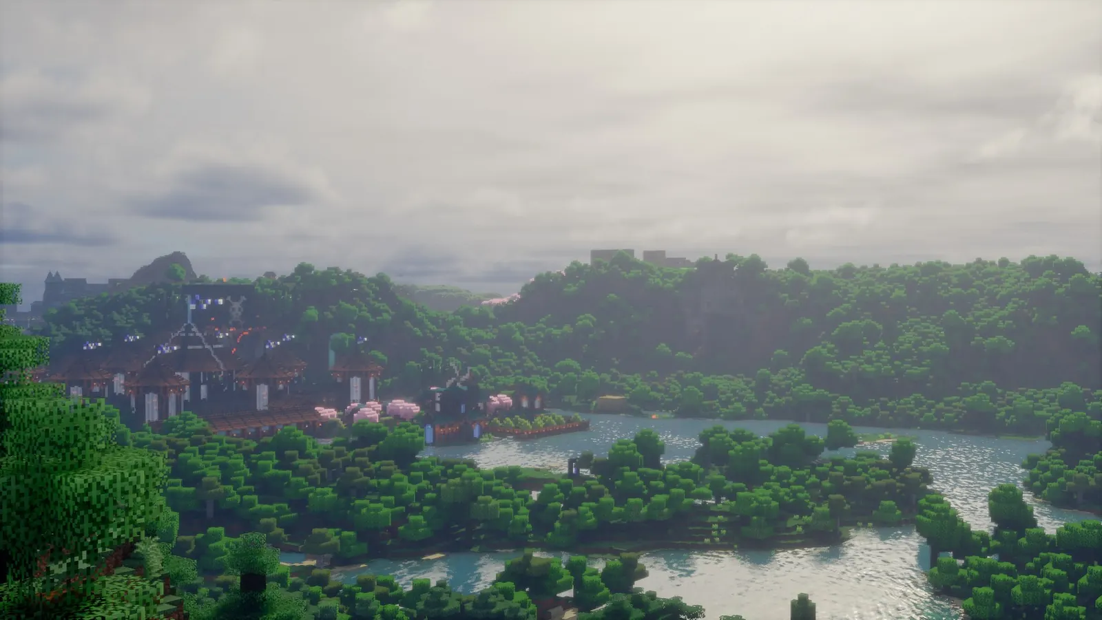 The RezzCraft spawn town seen across a forested valley and lake